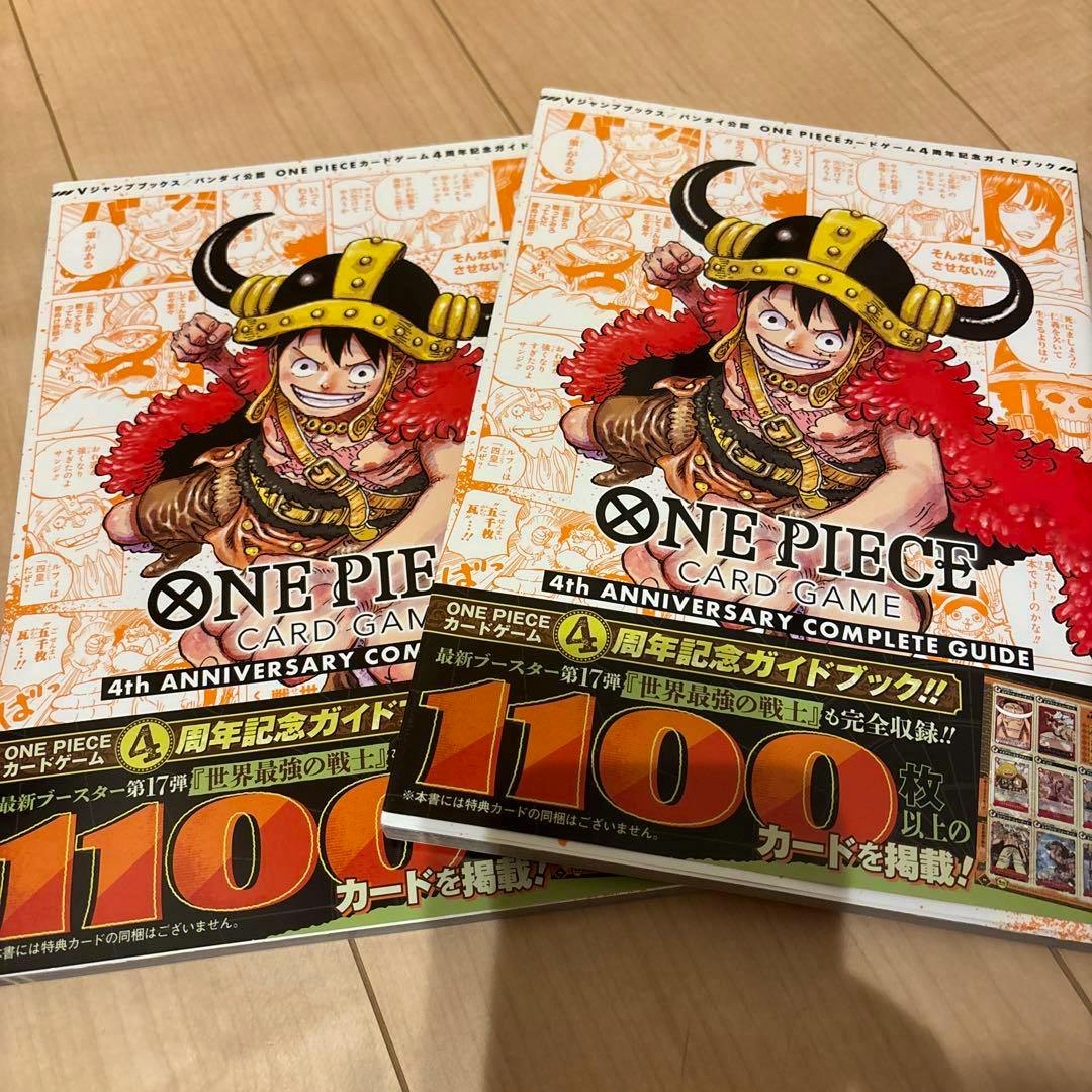 Two copies of the ONE PIECE 4th Anniversary Complete Guide book set showing the front cover illustration of Luffy, laid on a wooden floor.