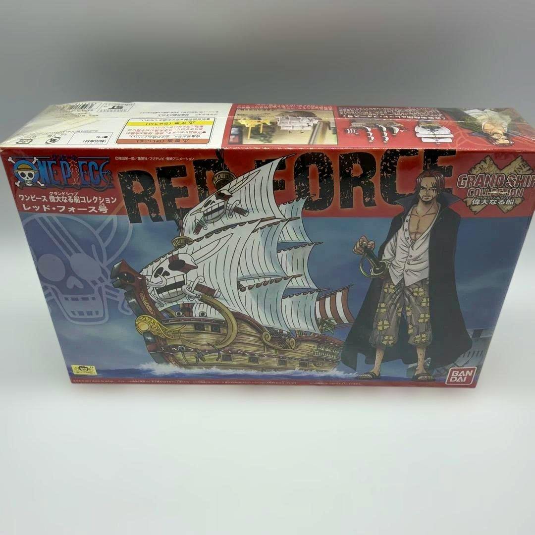 Front of the boxed Bandai One Piece Grand Ship Collection model kit for the Red Force ship showing the ship artwork, character art, and Bandai logo.