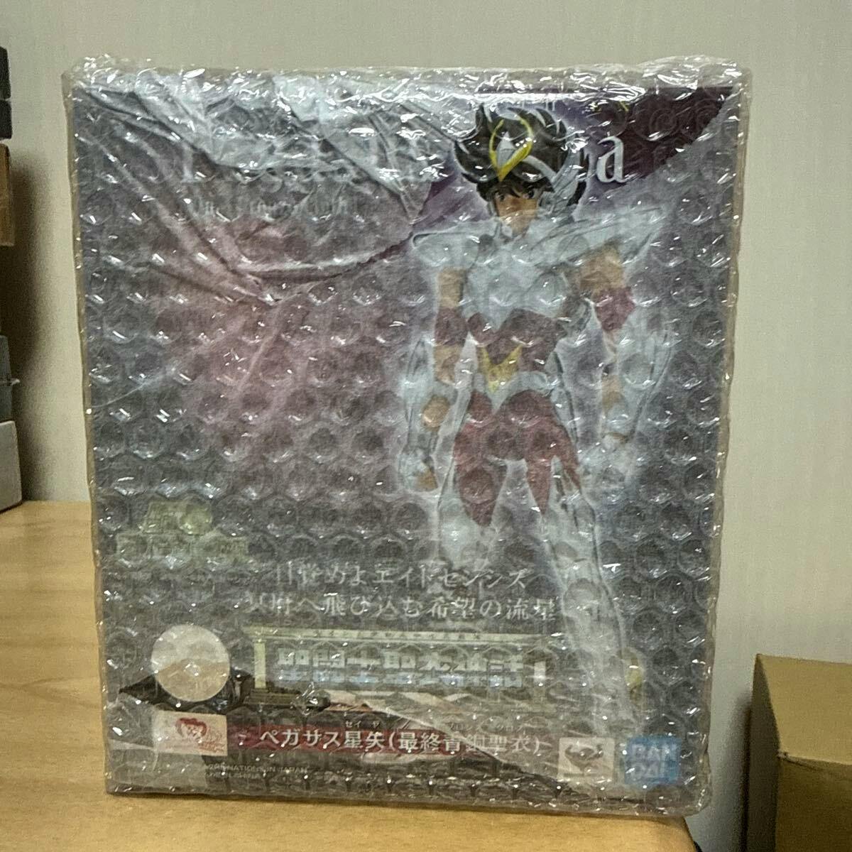 A Bandai Saint Seiya Pegasus Seiya figure box wrapped in bubble wrap sitting on a wooden surface.
