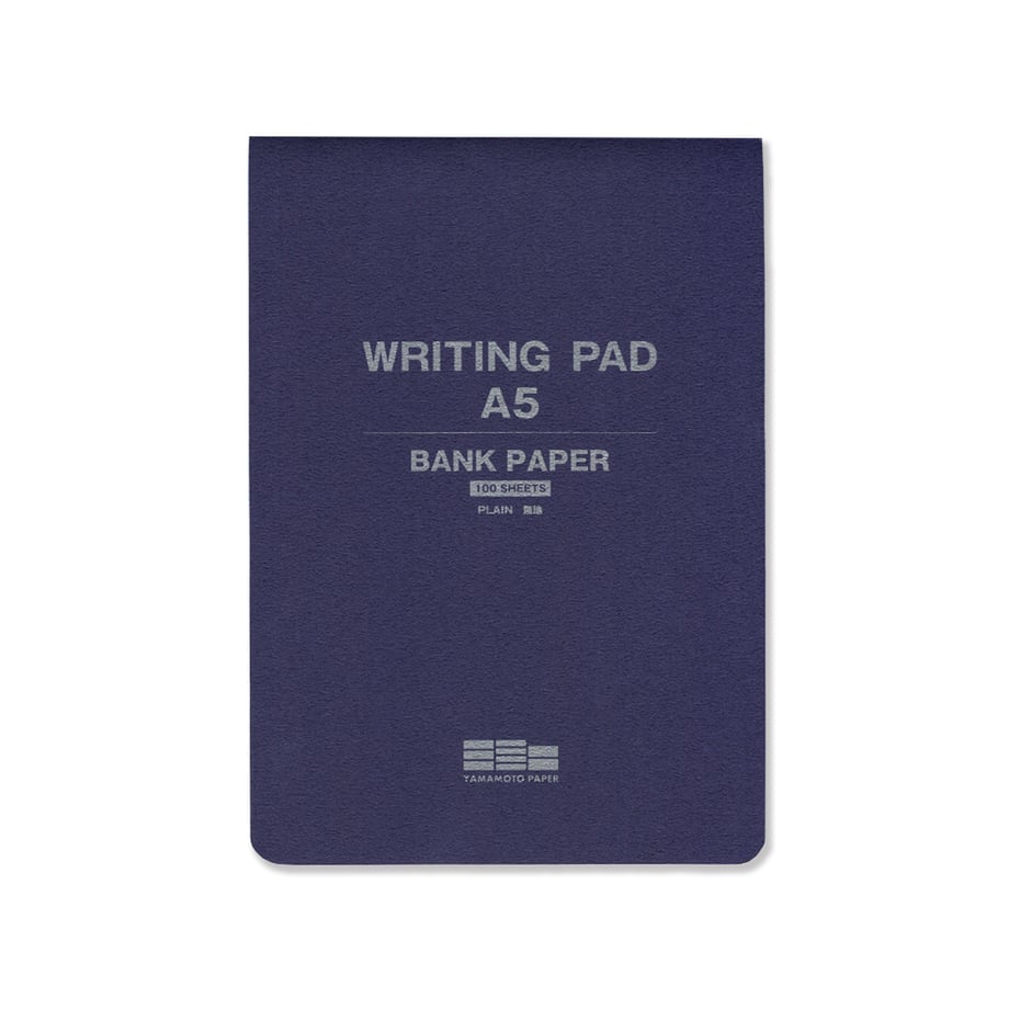 A navy A5 writing pad with cover text reading "WRITING PAD A5 BANK PAPER".