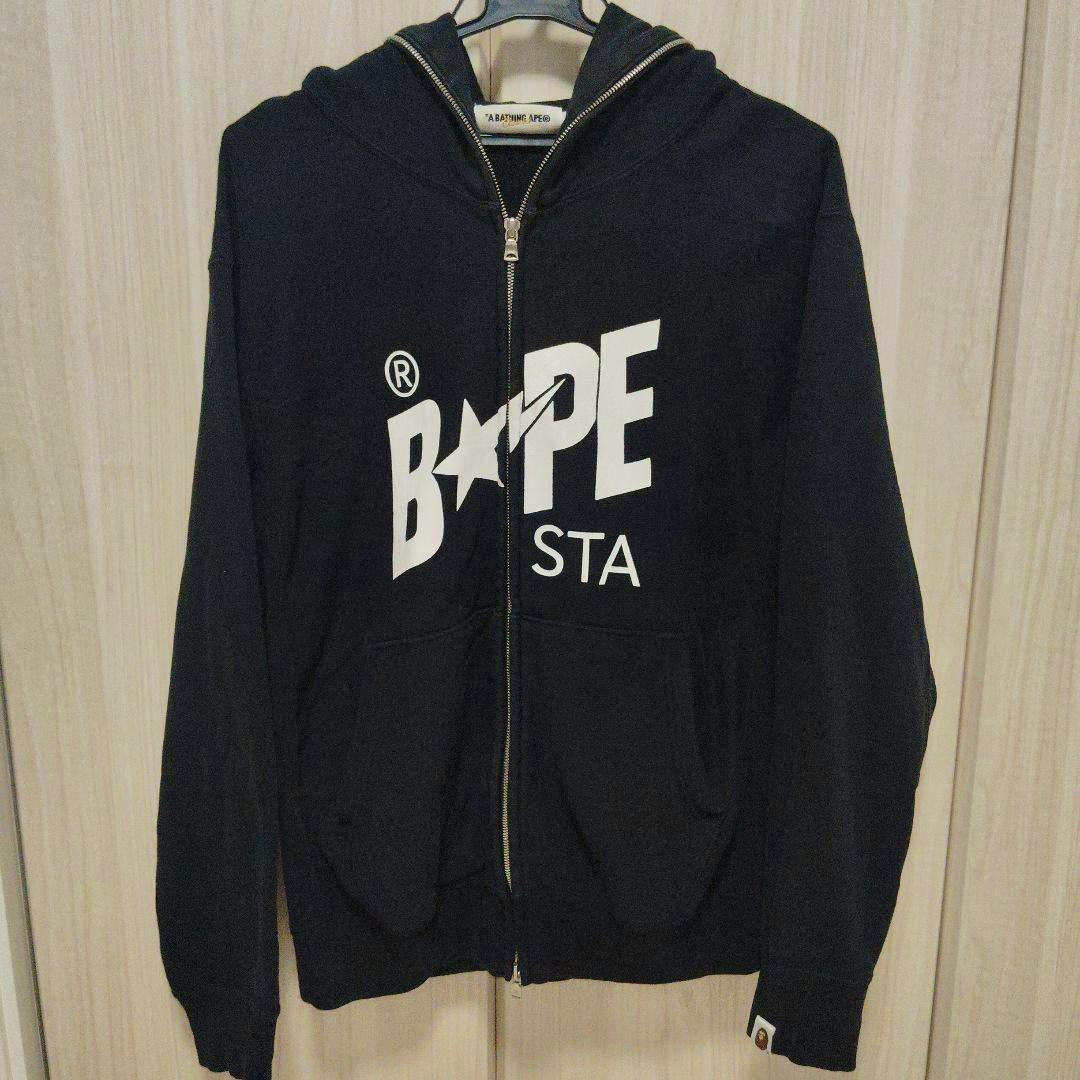 Black BAPESTA LOGO zip-up hoodie shown front-on with a large white BAPE STA logo across the chest.