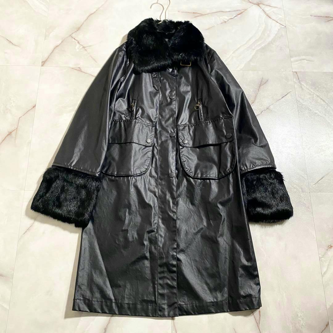 Front view of a women's black cotton coat with a fur collar and fur cuffs laid flat showing front pockets and button/zip closure.