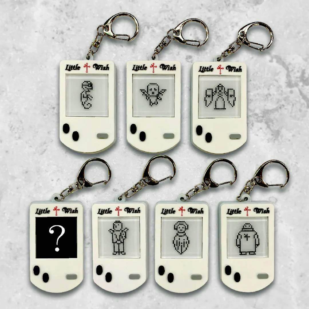 Seven white "Little Wish" rubber keyholder charms with pixel-art characters and metal key rings arranged in two rows.