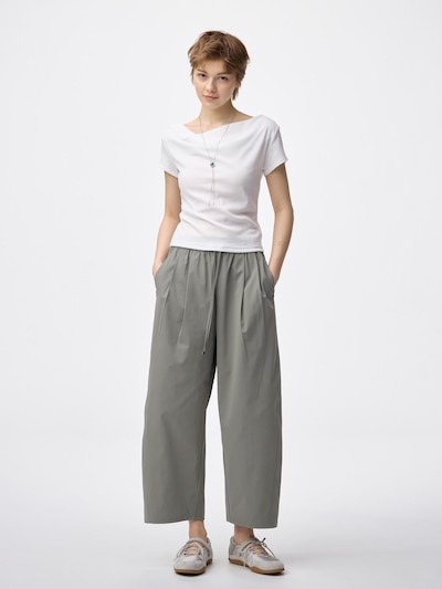 Model wearing gray women's polyester pants standing with hands in pockets.