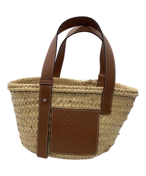 Front view of a woven straw basket bag with brown leather handles and a square leather patch on the front.