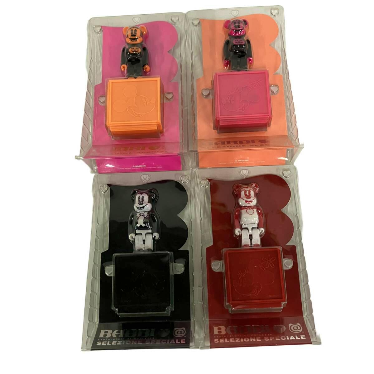 Four BE@RBRICK figures in their blister packaging arranged in a 2x2 grid on a white background.