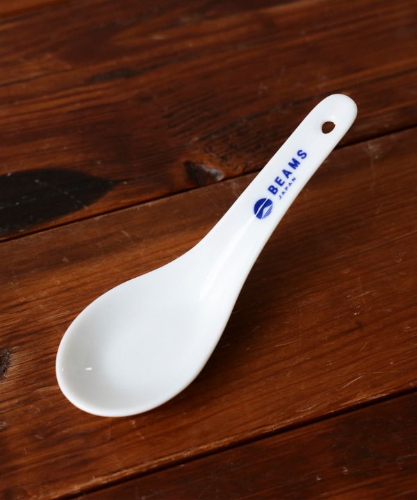 Ceramic spoon with the BEAMS Japan logo on the handle placed on a wooden surface.