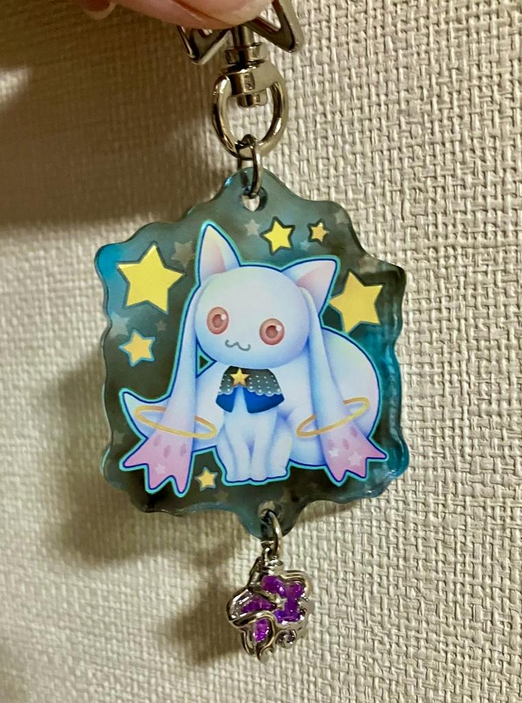 Close-up of an acrylic keychain showing the character ベベ with star motifs and a small purple dangling charm.