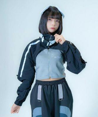 Front view of a model wearing the belted cropped nylon top against a plain background.