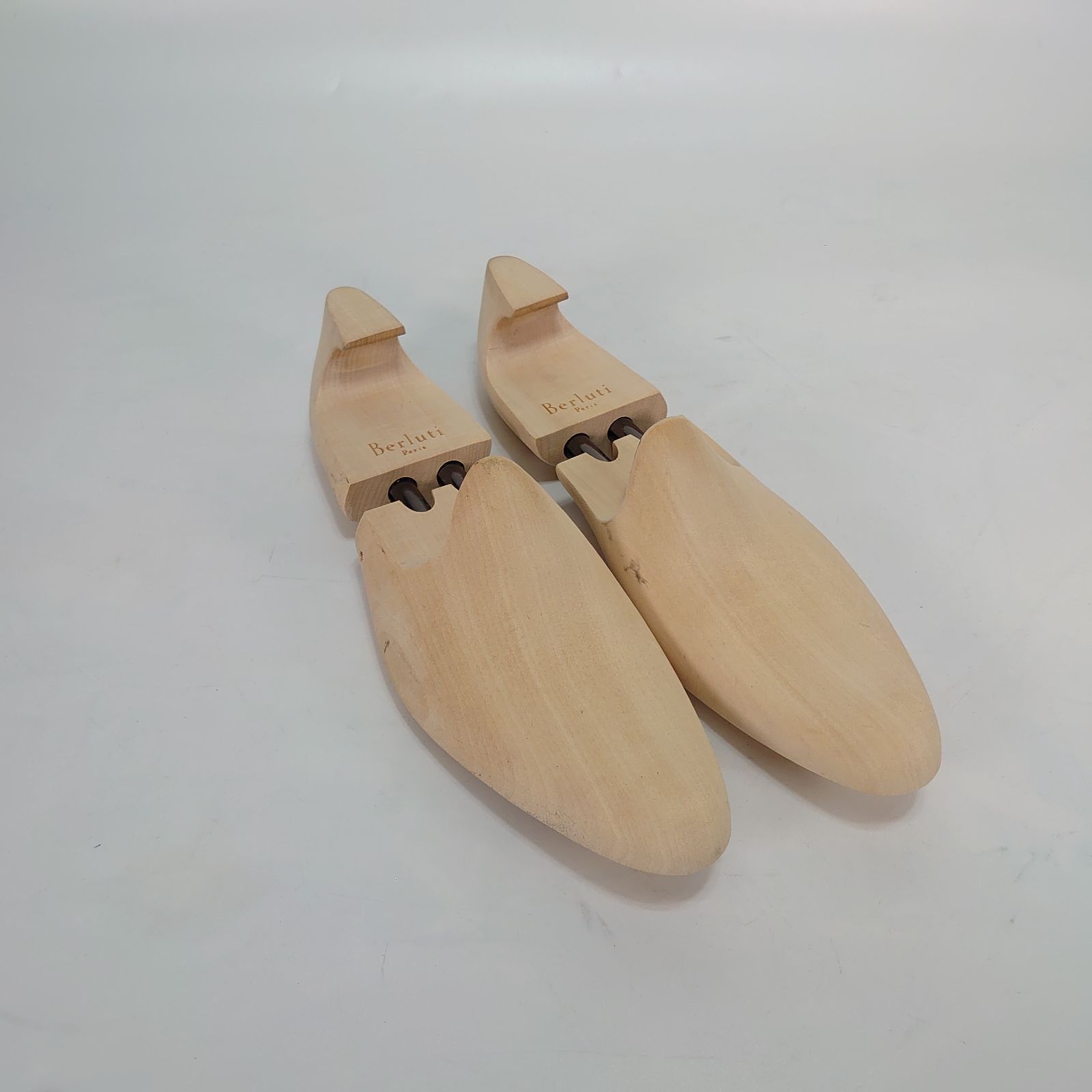 Pair of Berluti wooden shoe trees photographed on a white background.