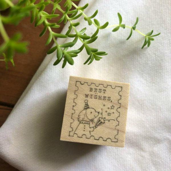 Wooden stamp block showing a dog-themed stamp design with the text "BEST WISHES".