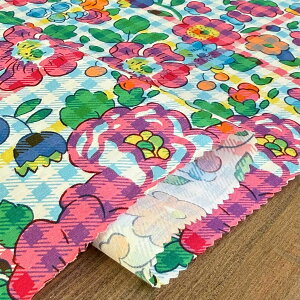 Folded Betsy Check (Saxe x Pink Floral) fabric showing the floral print on a wooden surface.