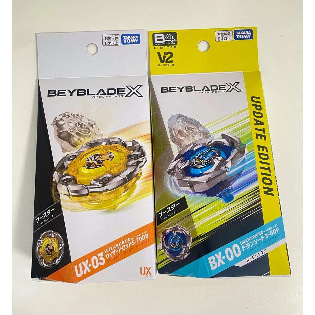 Two boxed Beyblade X toys (UX-03 ウィザードロッド and BX-00 ドランソード) shown side by side on a white background.