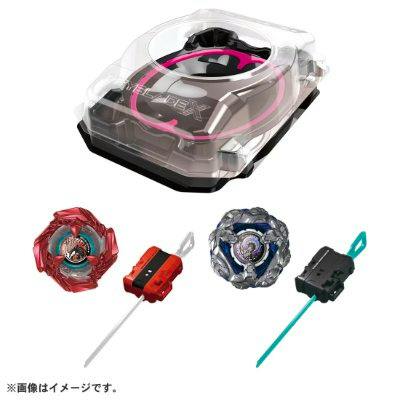 A Beyblade X battle entry set showing a clear plastic battle stadium, two Beyblade tops, and two launchers.