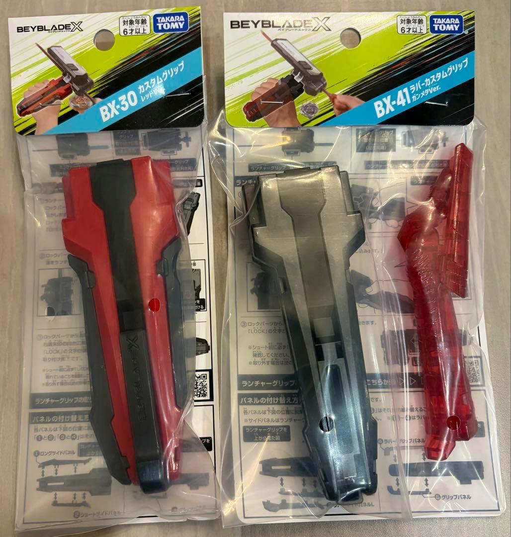 Two packaged Beyblade X custom grips labeled BX-30 and BX-41 are shown side by side in their plastic packaging.