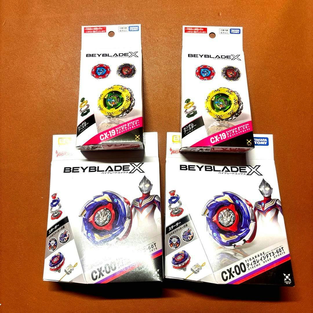 Photo of four Beyblade X boxed products, showing CX-00 and CX-19 packaging on a brown background.