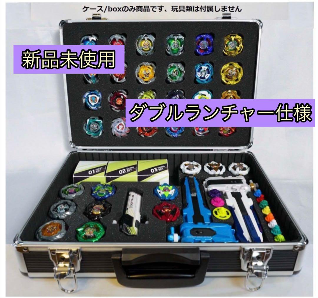 Open DREAMBOX plastic case with foam insert containing multiple Beyblade tops and launchers.