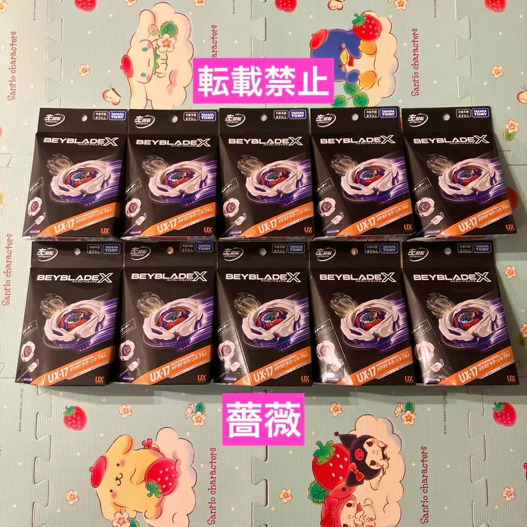 Ten boxed Beyblade X UX-17 Meteor Dragoon toys arranged in two rows on a patterned play mat.