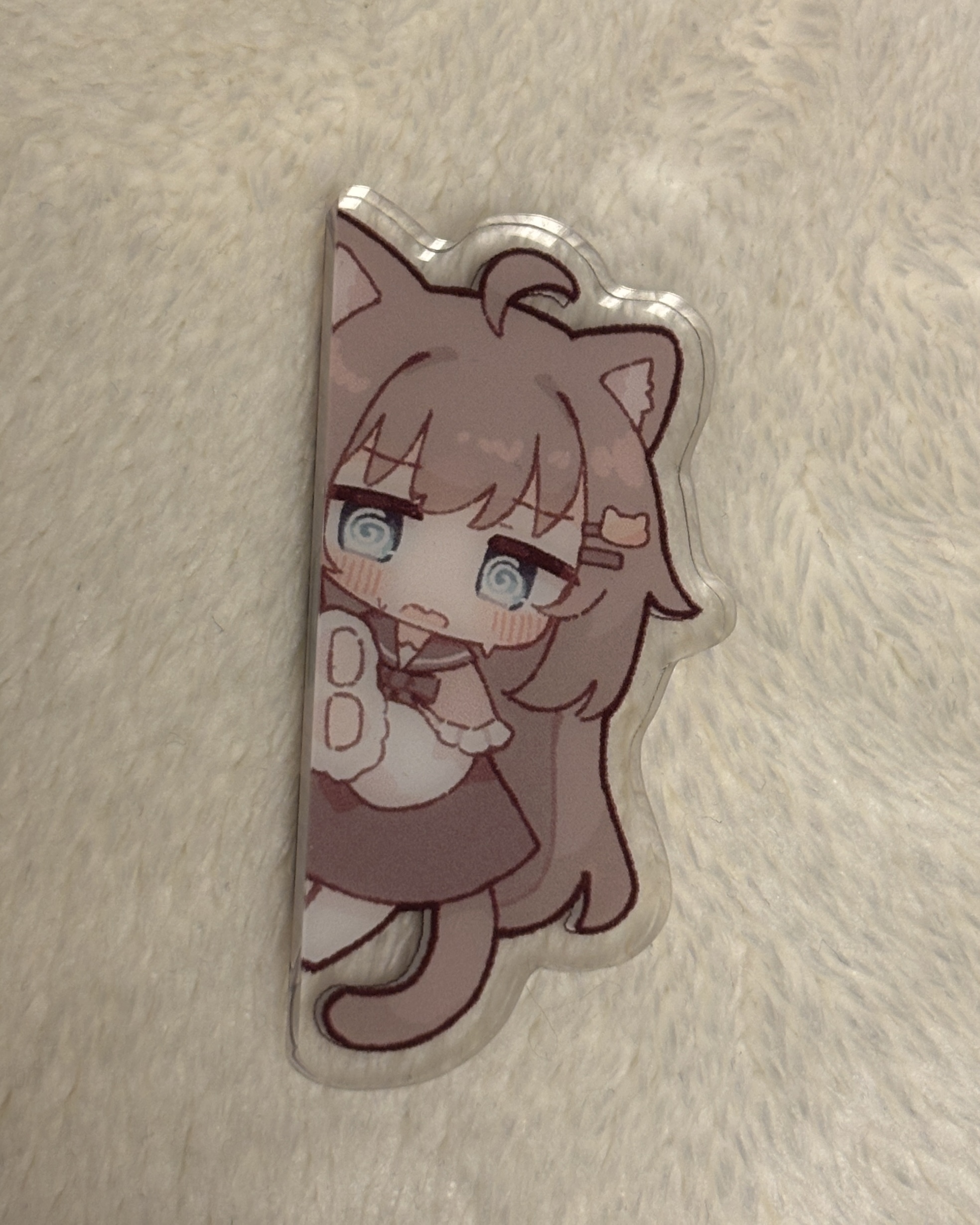 Acrylic fridge magnet depicting a chibi cat-eared girl character on a light fuzzy surface.