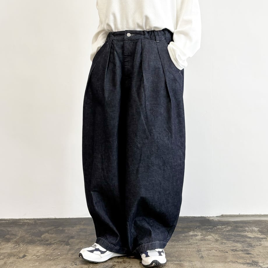 Front view of a model wearing BIG DENIM CIRCUS PANTS (ONE WASH) in dark denim with hands in pockets and sneakers.