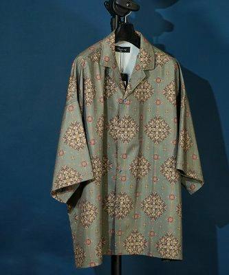 Front view of the men's polyester open-collar big-silhouette aloha shirt with all-over print hanging on a hanger against a blue background.