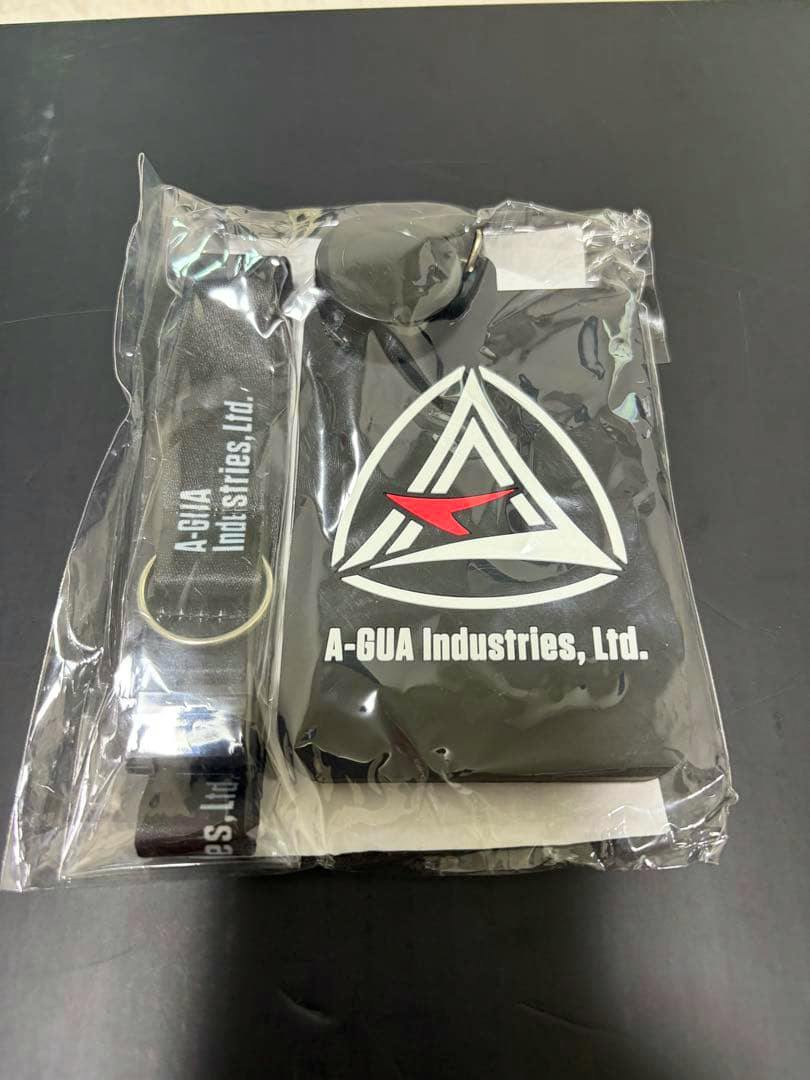 Photo of the pass case and lanyard sealed in plastic packaging showing an A-GUA Industries, Ltd. logo.
