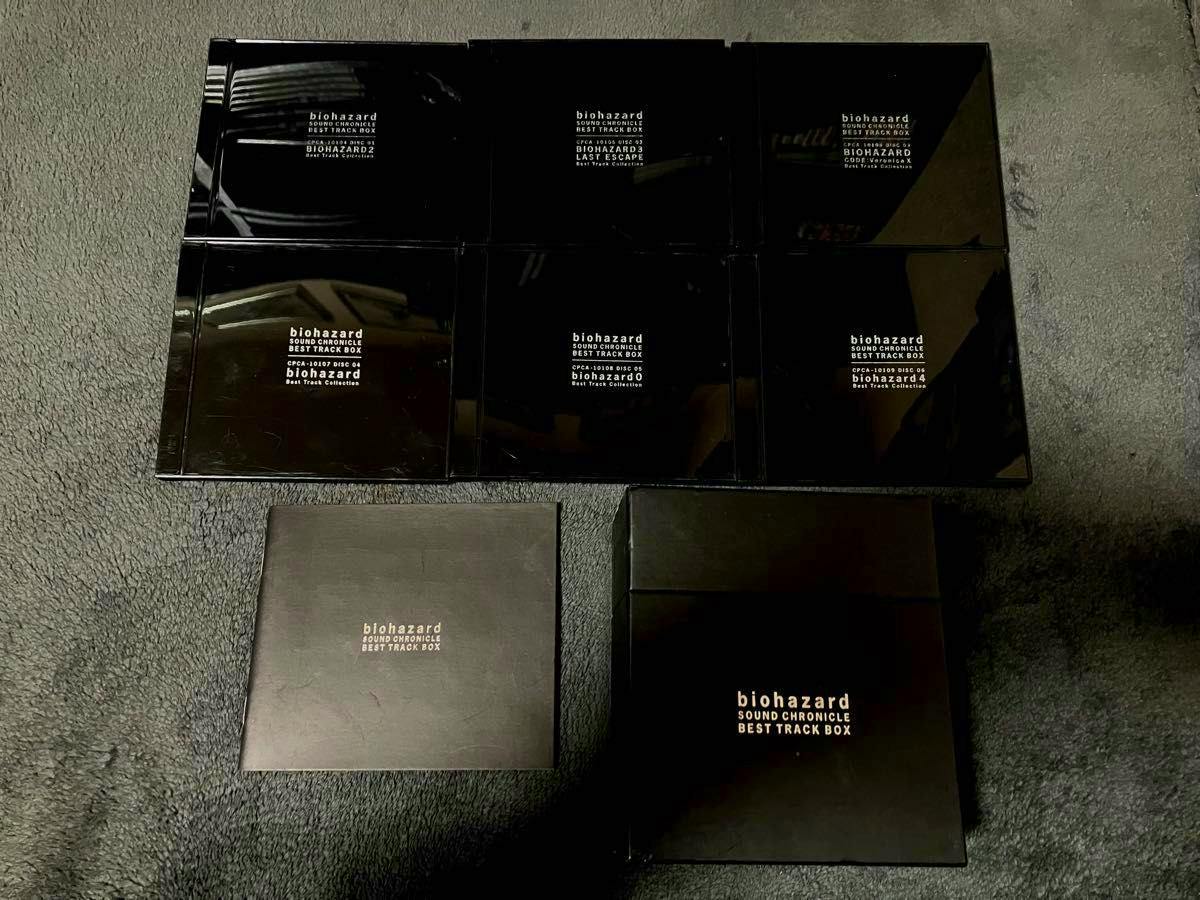 Black "biohazard SOUND CHRONICLE BEST TRACK BOX" CD box set with six glossy disc cases and two box pieces arranged on a dark surface.