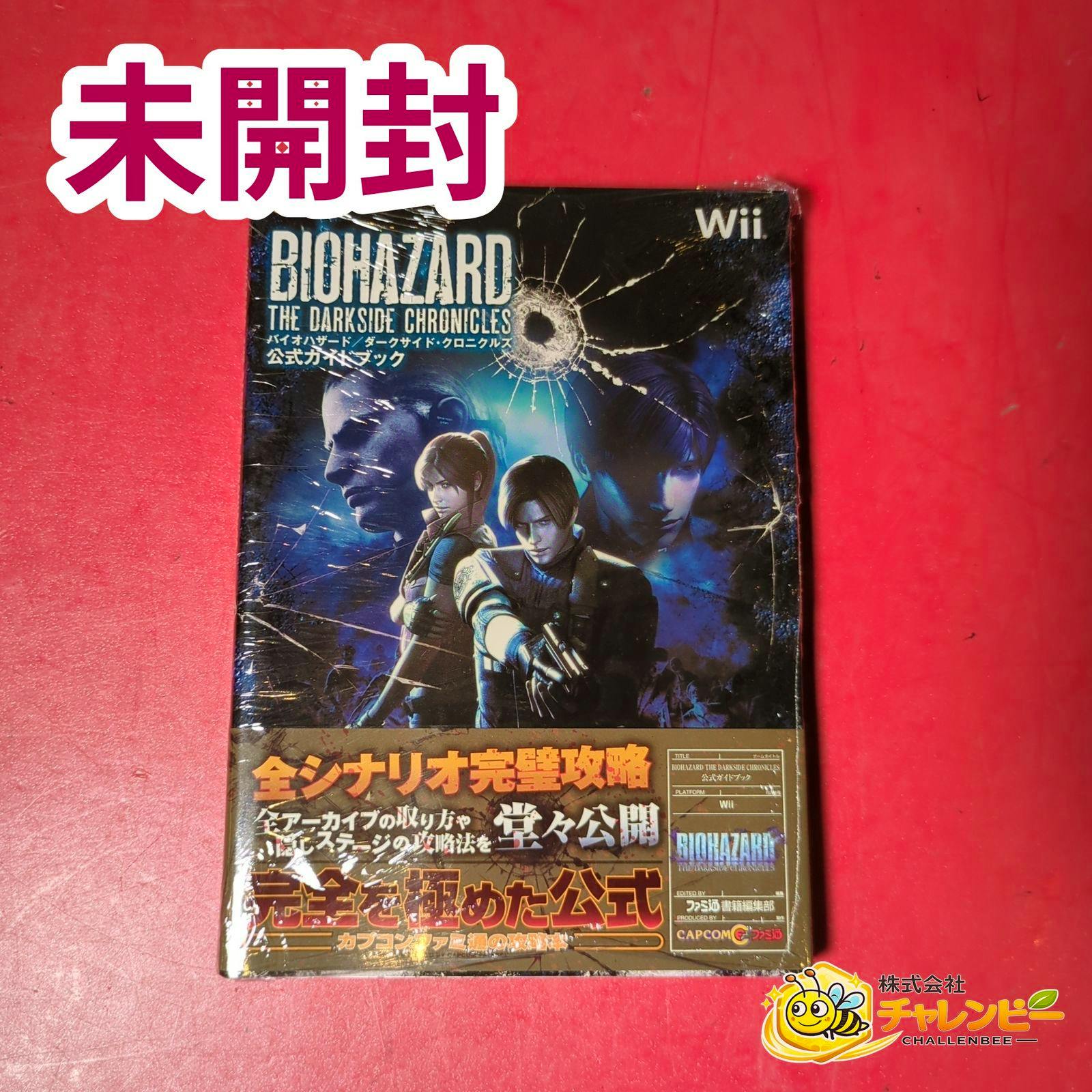 Front cover of the Wii Biohazard: The Darkside Chronicles official guidebook wrapped in plastic on a red background.