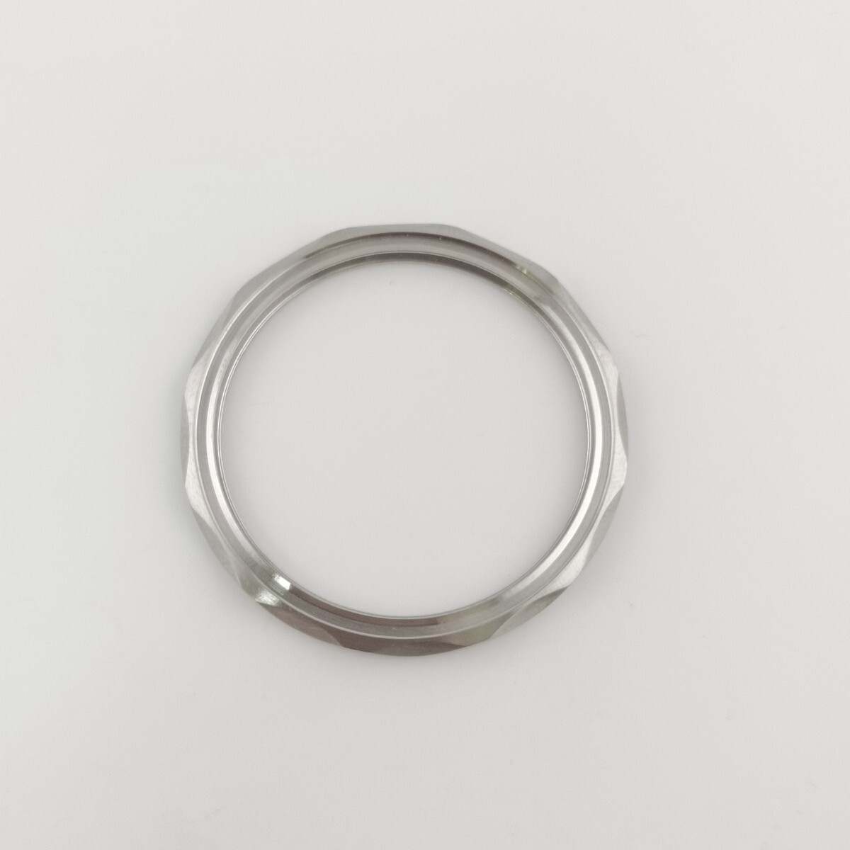 Metal watch bezel ring photographed on a white background.
