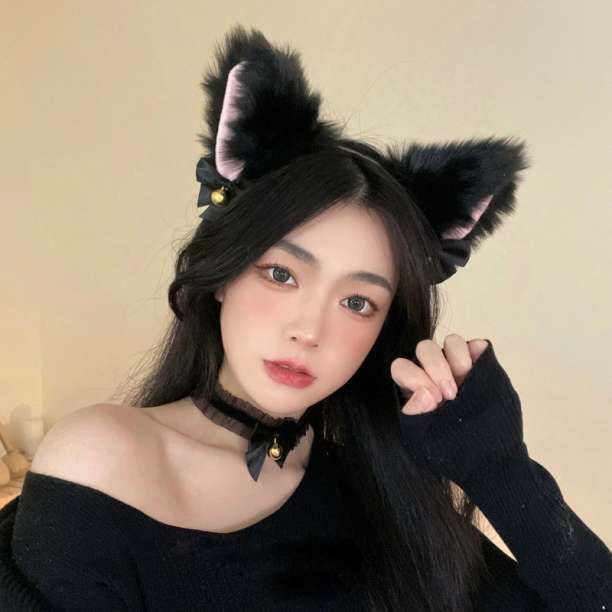 Model wearing a black fluffy cat-ear headband with a small bell.