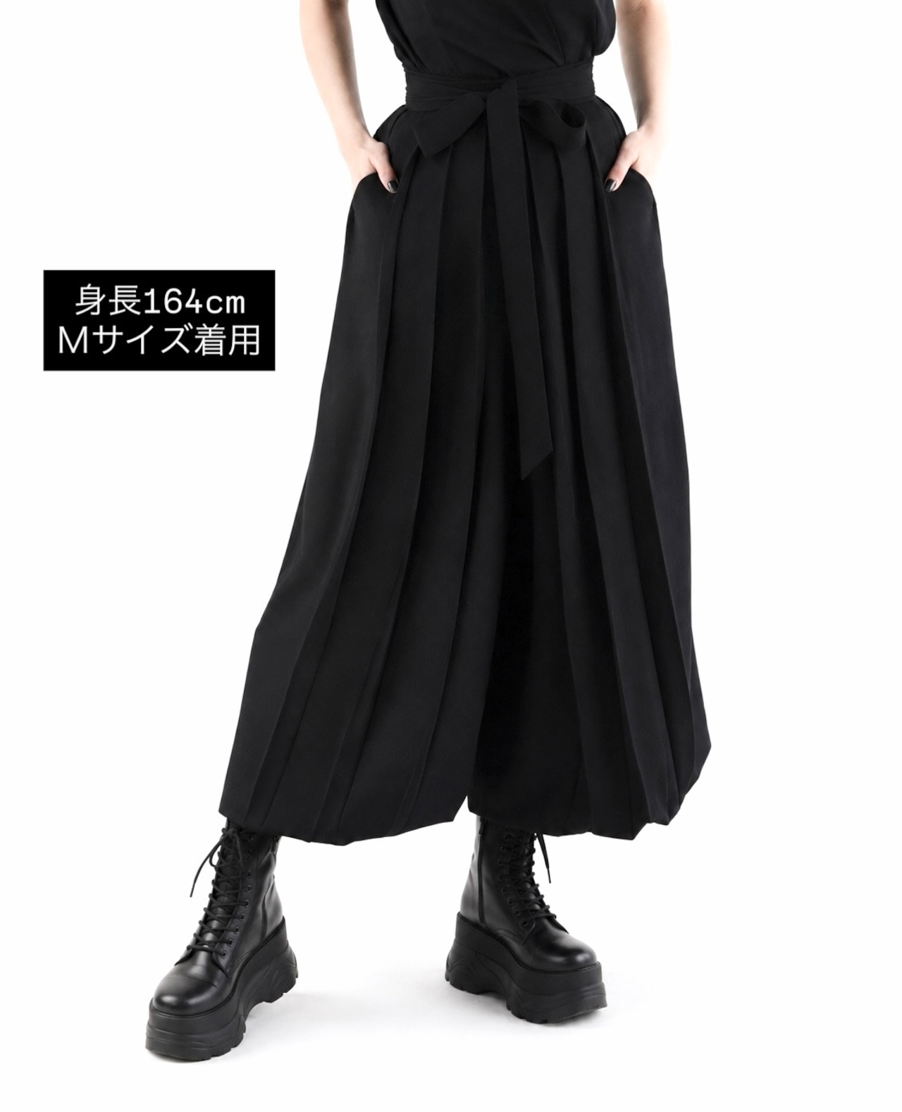 Model wearing black hakama-style women's pants shown from waist to ankles.