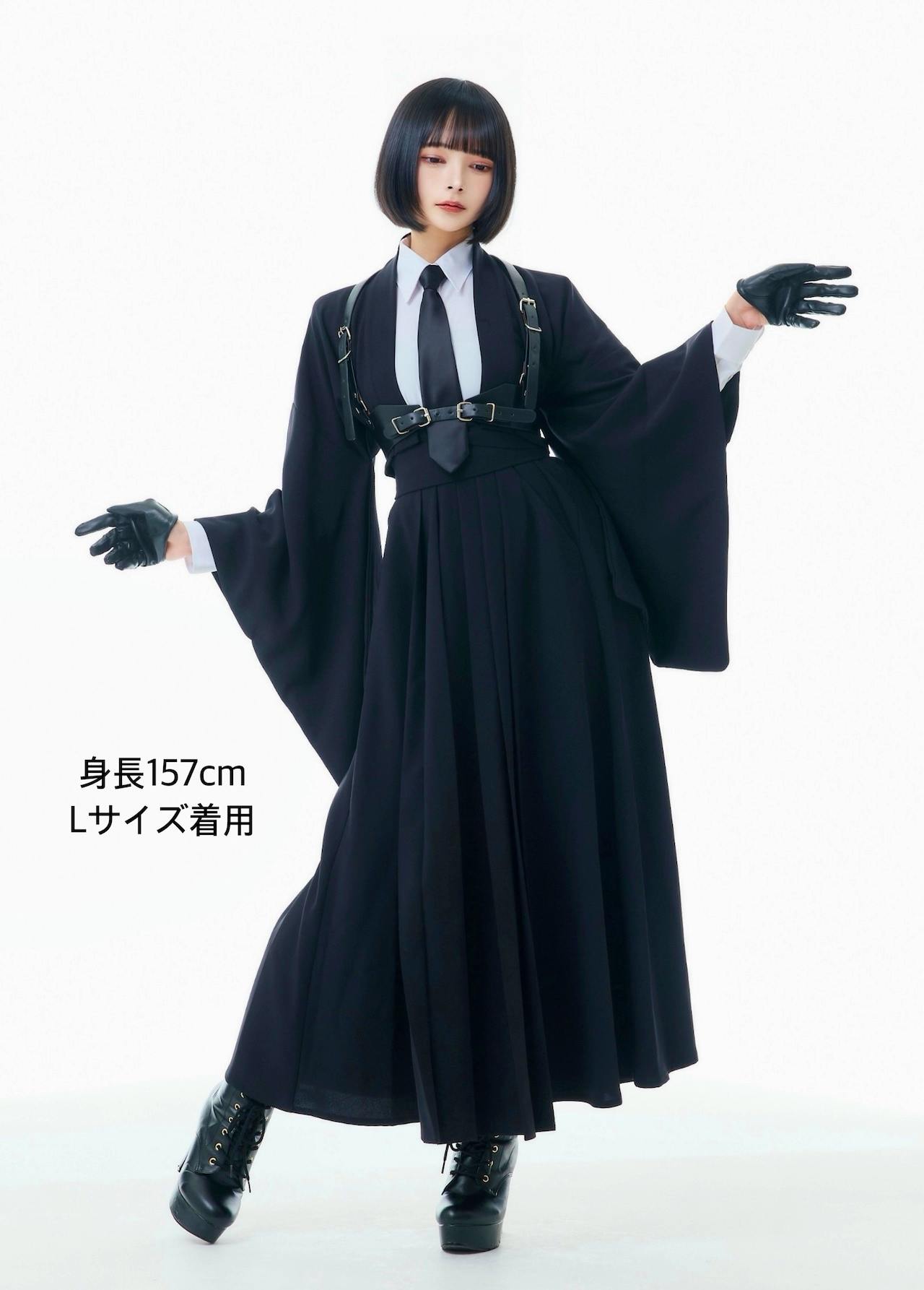 Female model wearing the black hakama-style skirt shown full length with pleats, paired with a white shirt and black accessories.