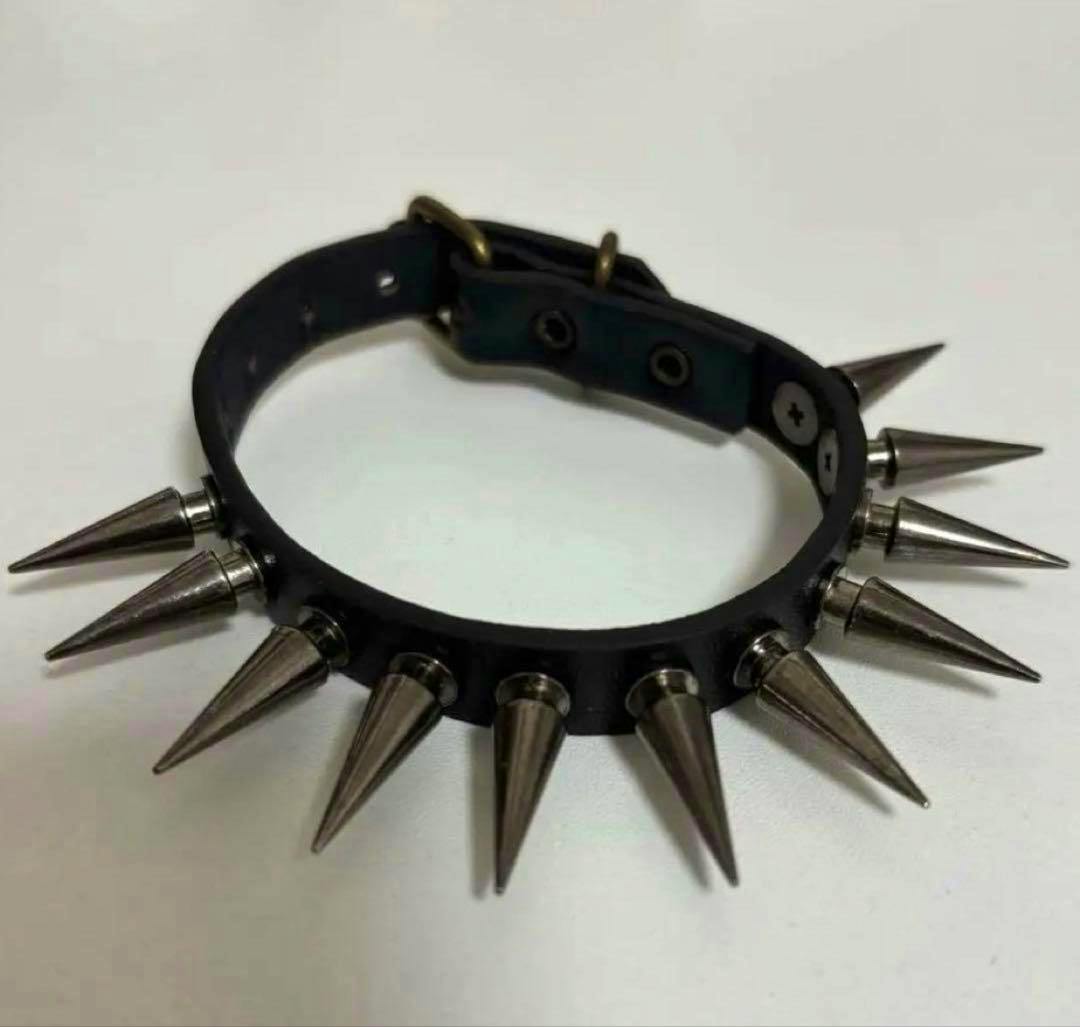 Black stud bracelet with metal cone spikes shown on a white background.