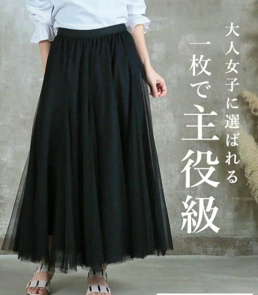 Front view of a black tulle skirt worn by a model, shown from waist to ankles.