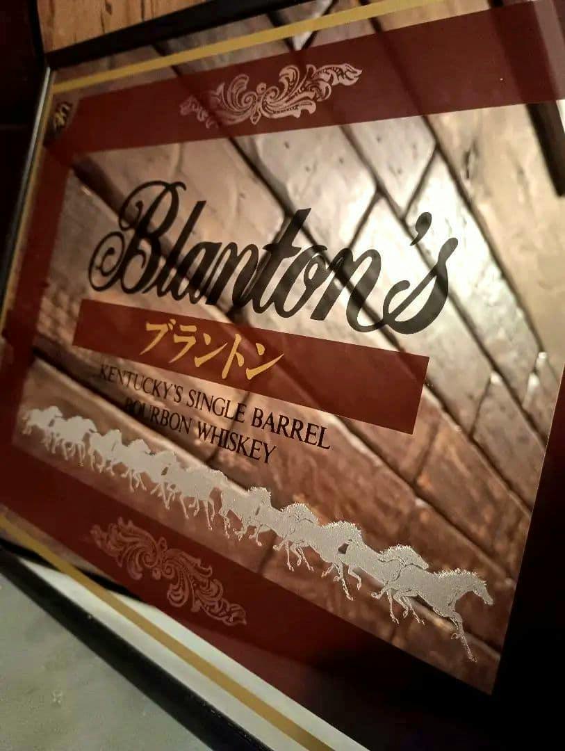 Close-up of the pub mirror showing the Branton's logo, Japanese text, and a row of galloping horses printed on the mirror.