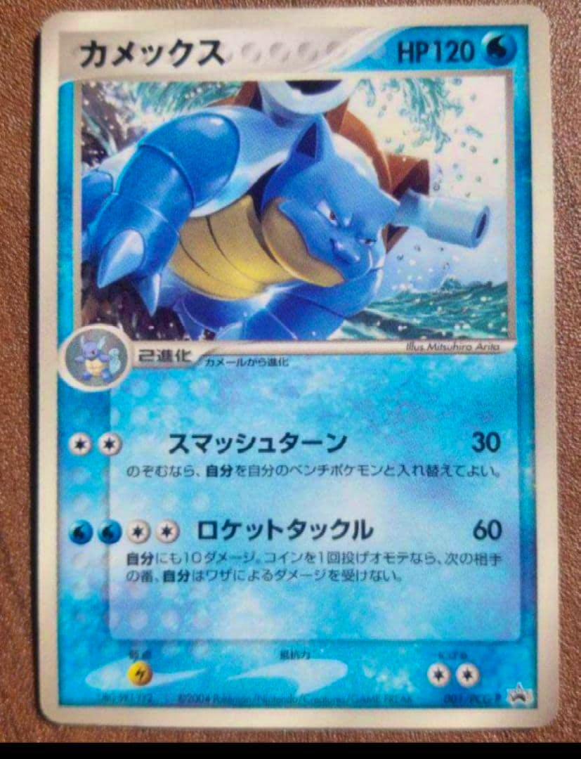 Front of a カメックス (Blastoise) promo Pokémon trading card showing the card artwork, HP and Japanese text.