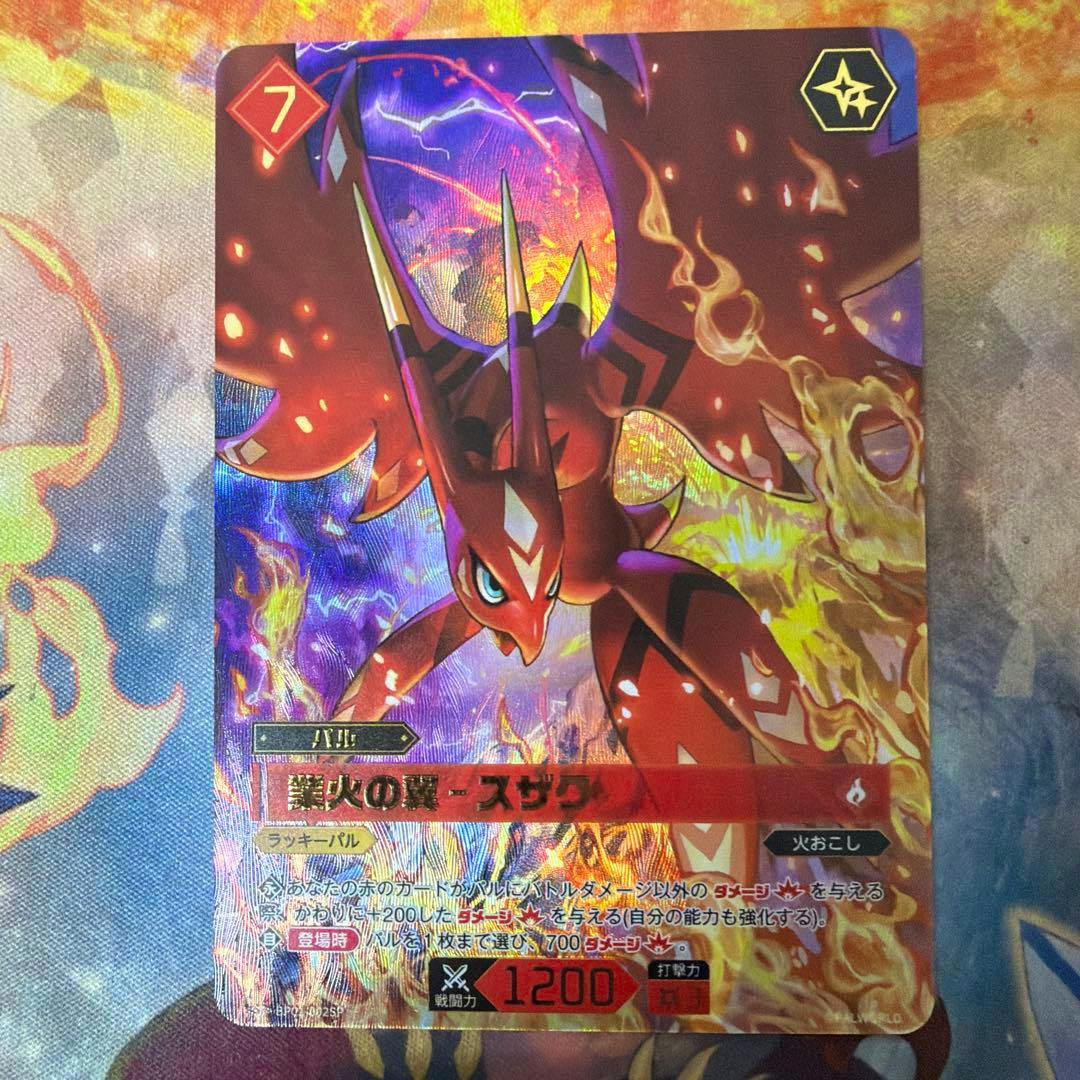 Front of the trading card "業火の翼 - スザク" (Palworld) showing the red creature artwork with holographic foil and Japanese text.