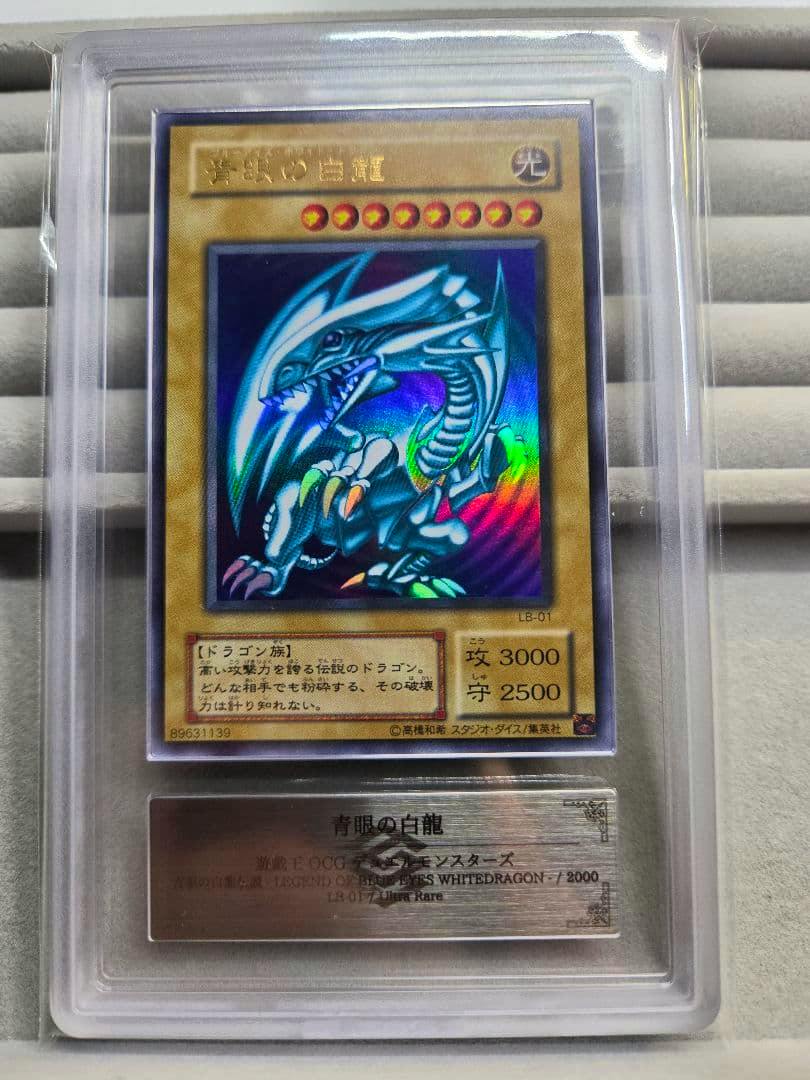 Front of a Blue‑Eyes White Dragon trading card (Japanese) shown inside a clear protective slab, displaying the holographic artwork and card text.