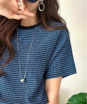 Model wearing a blue patterned short-sleeve women's top shown from shoulders to waist.