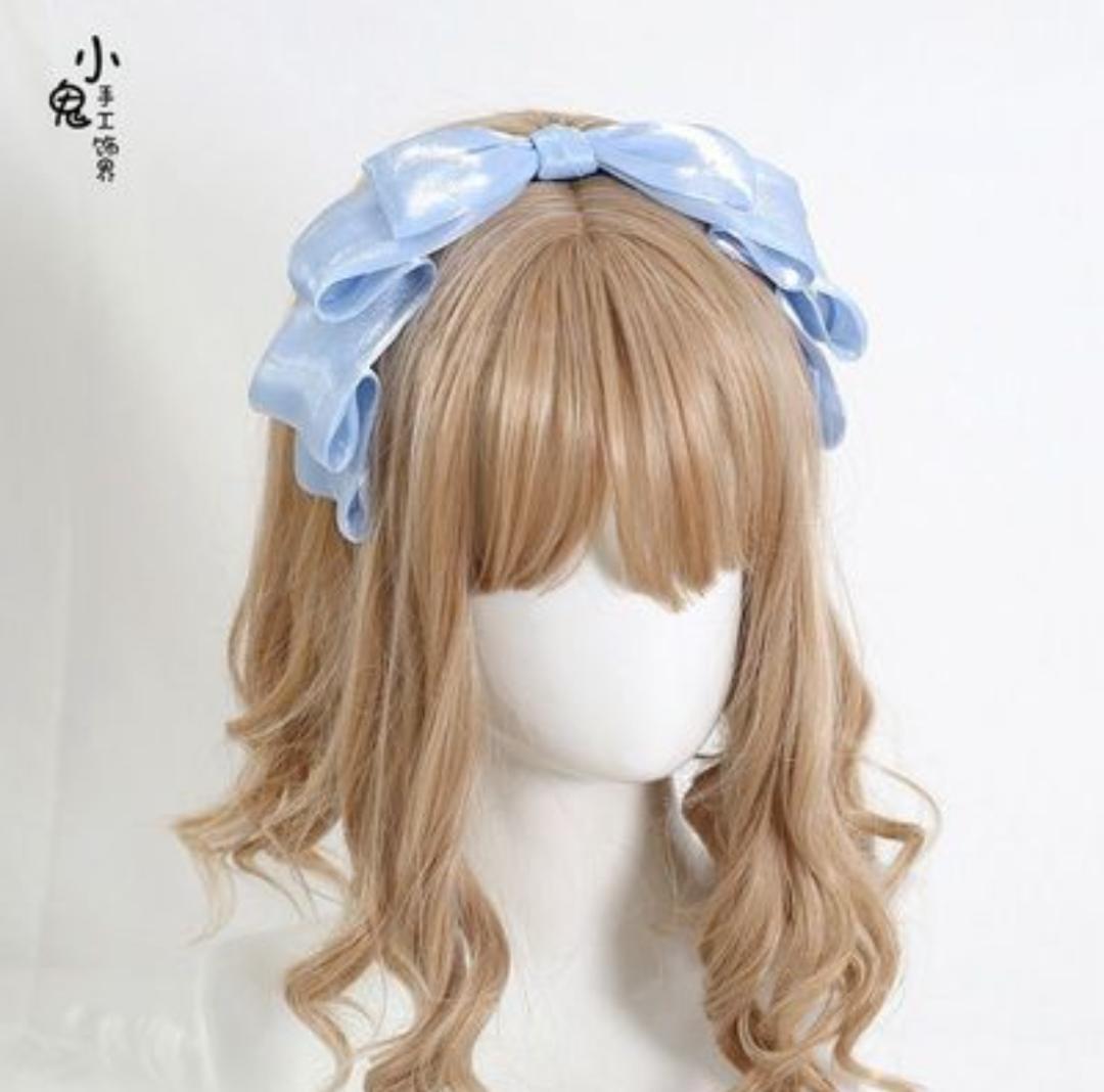 Blue ribbon headband displayed on a mannequin head with a wig.