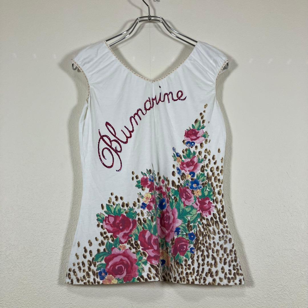 Front view of a white Blumarine sleeveless cotton shirt with leopard-pattern and pink floral print hanging on a hanger.
