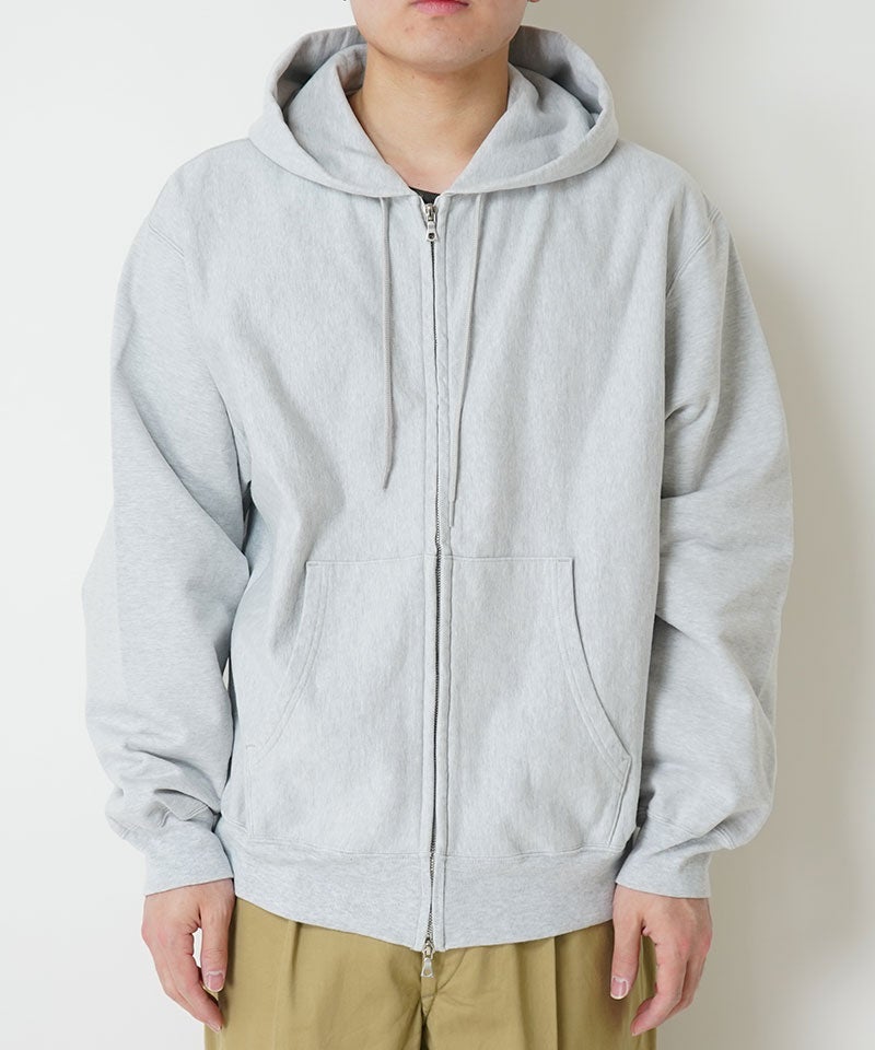 Front view of a light gray men's thin-sweat zip hoodie worn by a model.