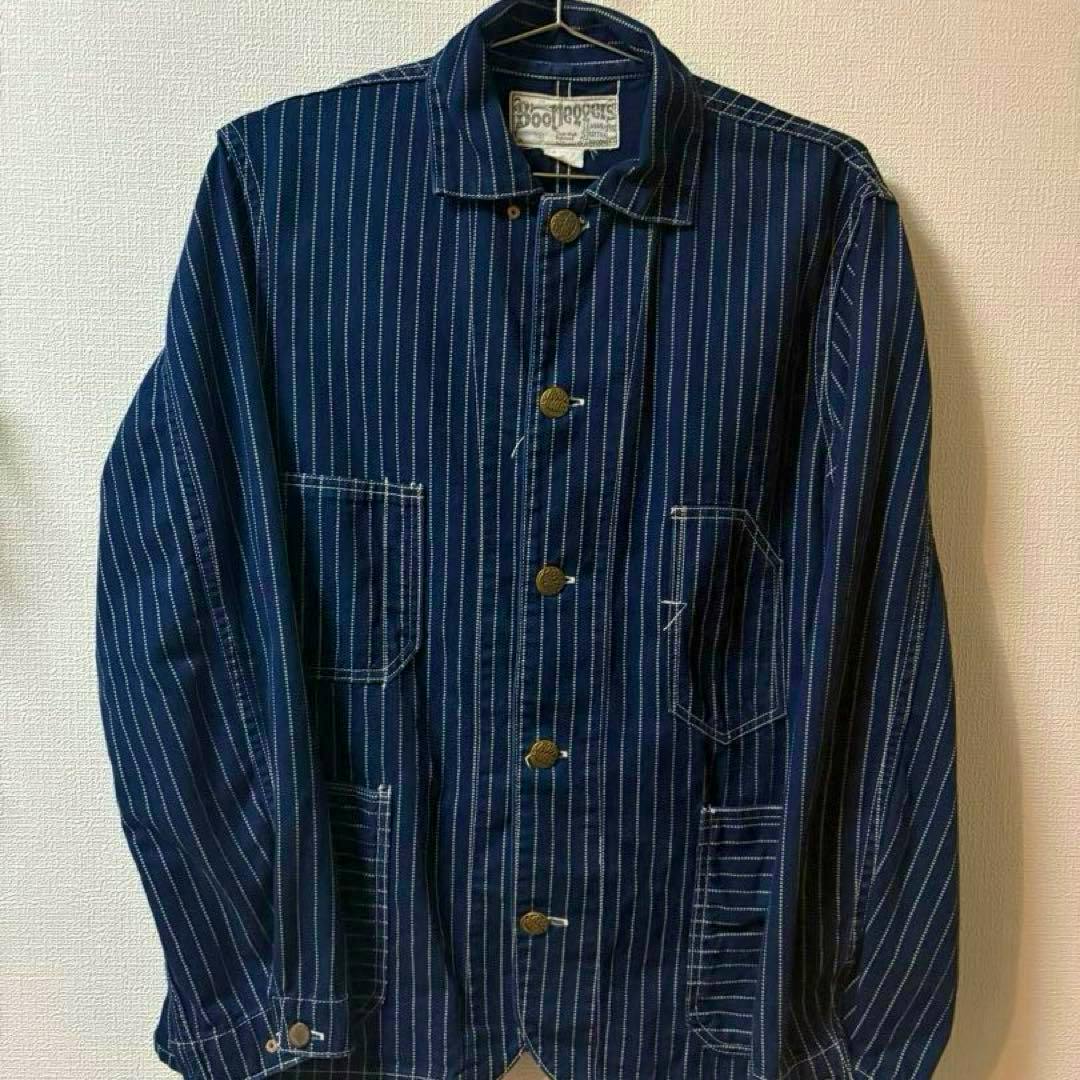 Front view of the BOOTLEGGERS BOLLWEEVIL CORTINDIGO WABASH striped jacket hanging on a hanger, showing buttons and front patch pockets.