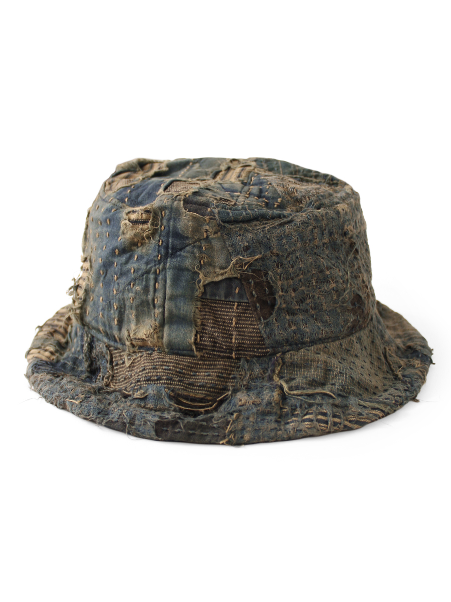 Patched boro-style cotton bucket hat with visible stitching and frayed edges on a white background.