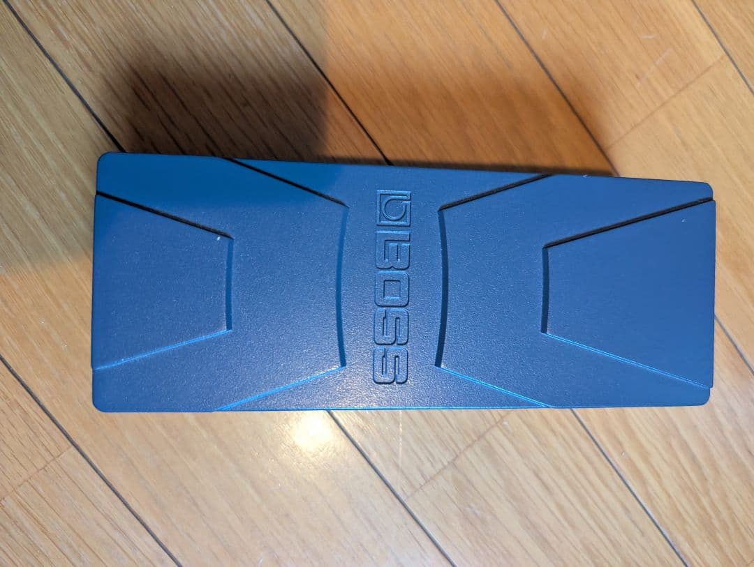 Top view of a BOSS EV-30 guitar expression pedal showing the pedal surface and BOSS logo on a wooden floor.