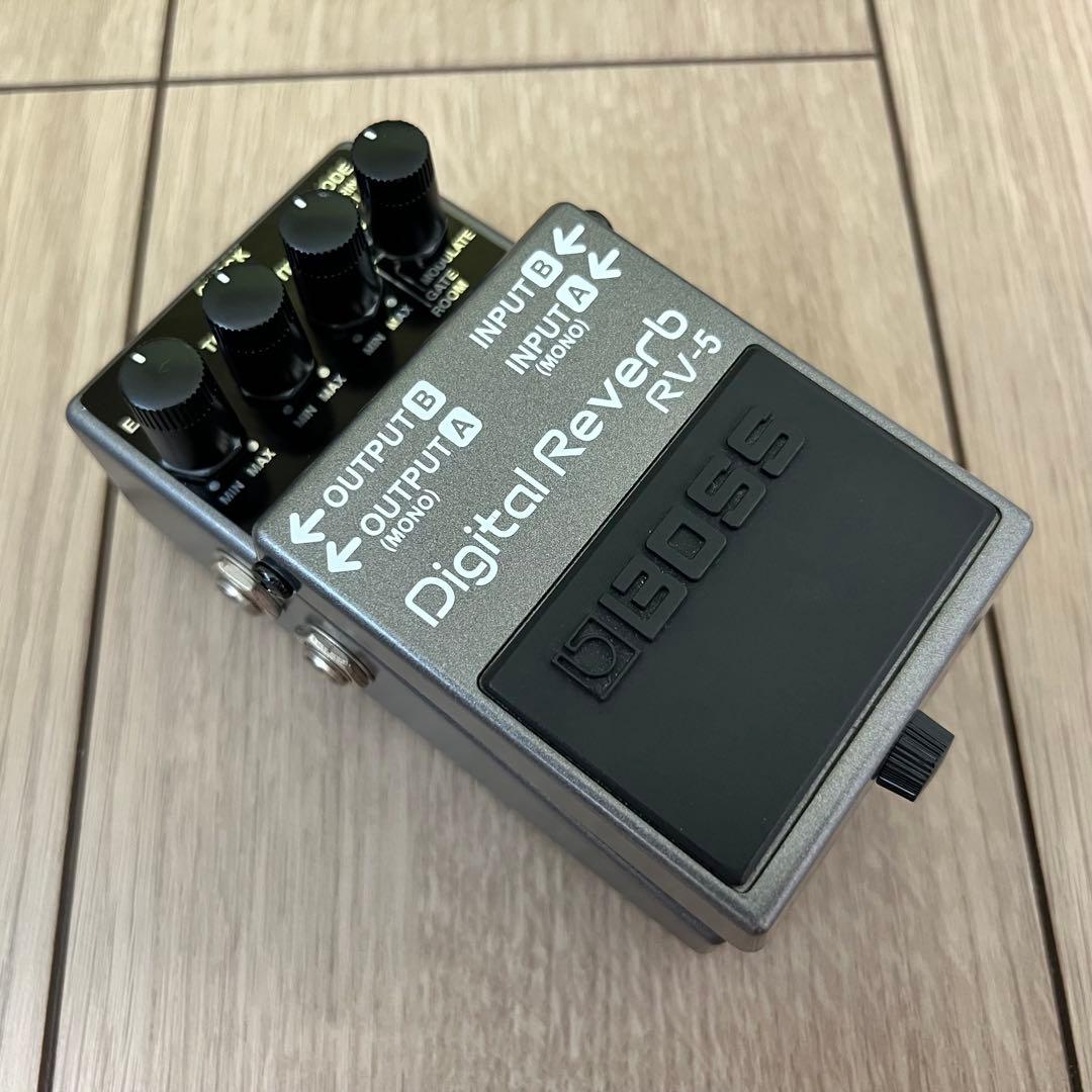 Angled photo of a BOSS RV-5 Digital Reverb guitar effects pedal on a wood floor, showing knobs and footswitch.