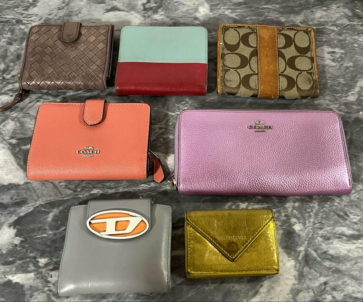 Seven wallets and coin cases arranged on a grey marbled surface, showing various colors and materials.