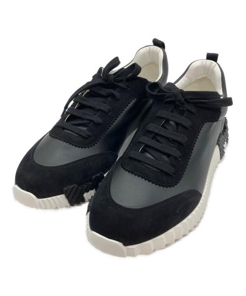 Angled top-front view of a pair of black textile sneakers with white chunky soles.