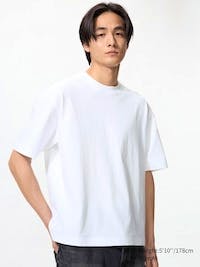 Male model wearing a white boxy cropped men's t-shirt against a plain light background.