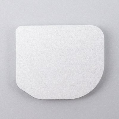 Silver metal battery plate photographed flat on a gray background.